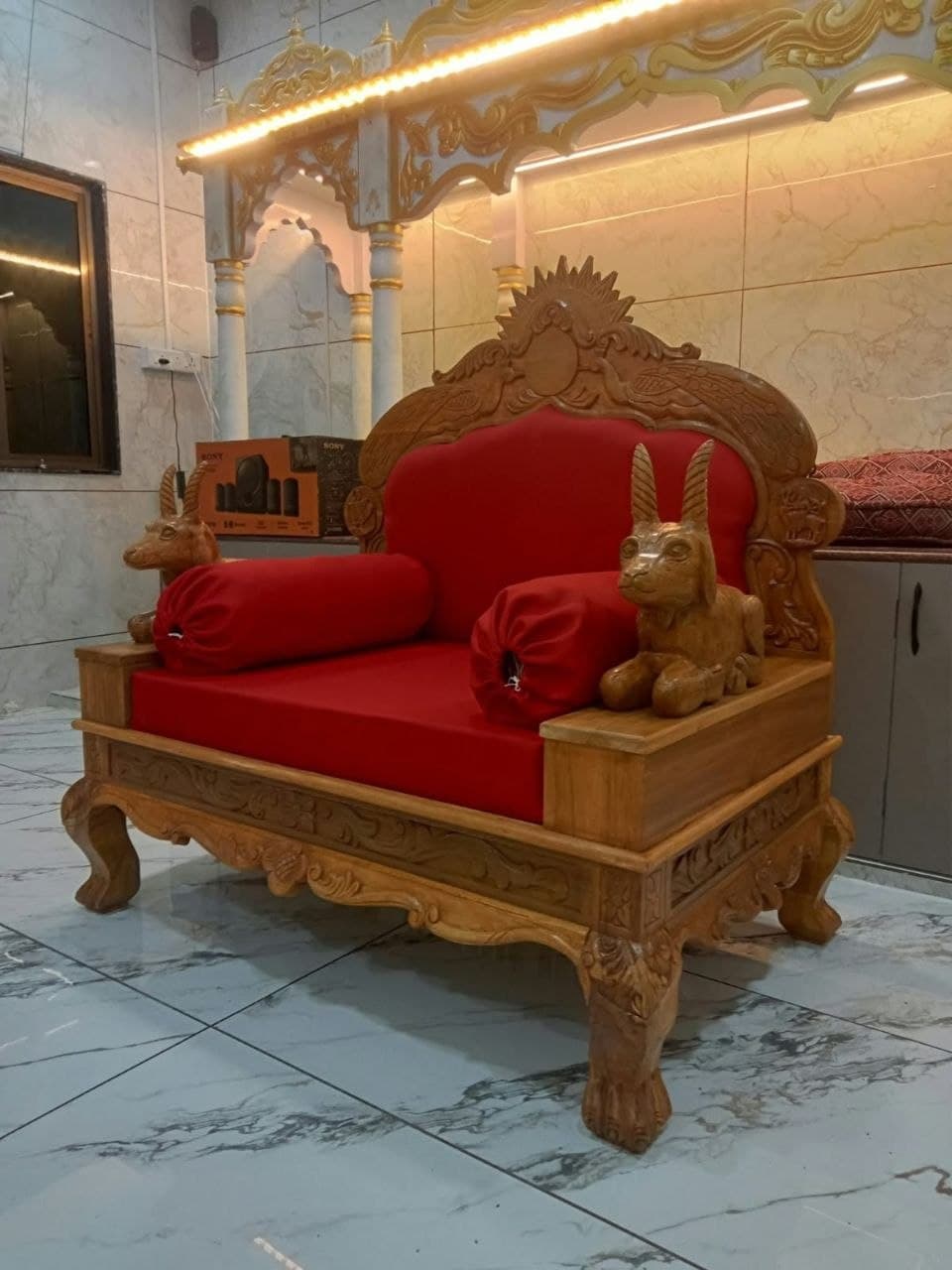 Royal carved wooden armchair with sculpted animal figures and red upholstery